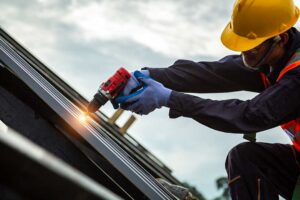 Residents sort shingles, metal flashing, and roofing debris into separate covered containers.